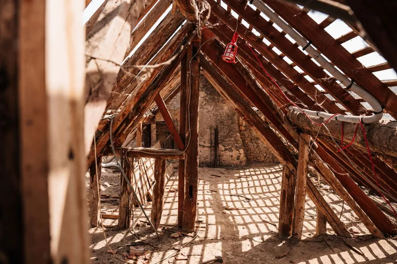 Old attic rafters with sunlight and dust on the floor